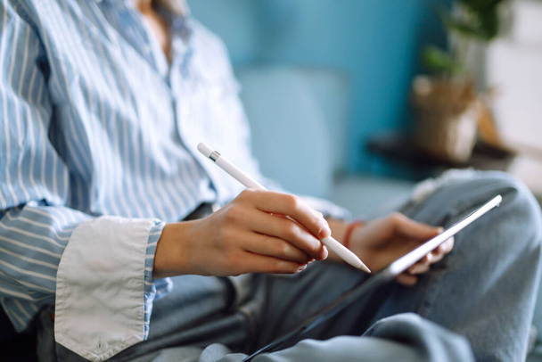 Mujer usando tableta digital con pantalla en blanco en el sofá en casa. La chica charlando con amigos en las redes sociales, compras en línea, escribiendo correo electrónico. Tecnología, freelance y concepto de trabajo
. - Foto, imagen