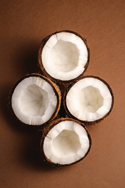 Кокосові фрукти на коричневому звичайному фоні, абстрактна їжа тропічна концепція, вид зверху
 - Фото, зображення