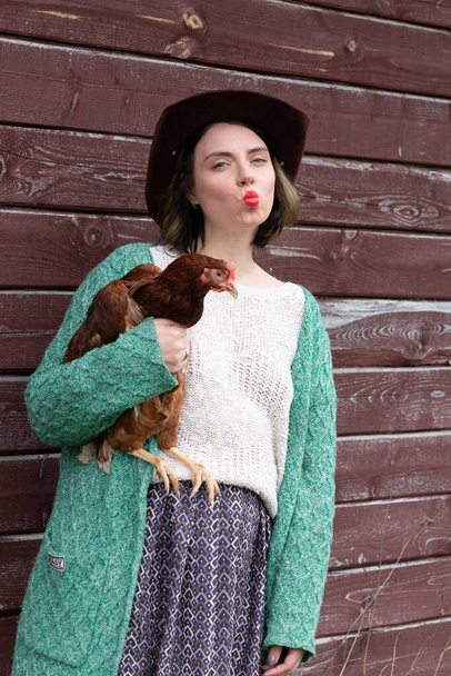 chica sosteniendo pollo en el pueblo
 - Foto, imagen