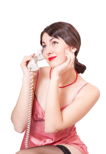 Fiatal gyönyörű nő egy régi telefon a kezében, elszigetelt fehér háttér - Fotó, kép