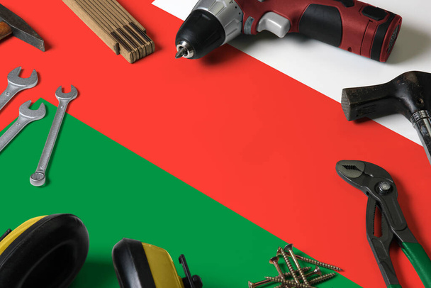 Oman flag on repair tool concept wooden table background. Mechanical service theme with national objects. - Zdjęcie, obraz
