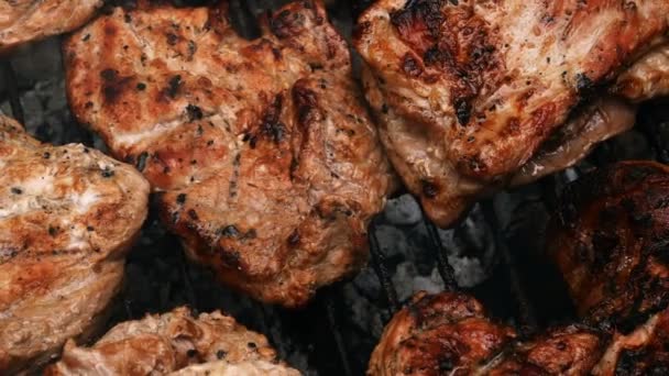 Grilling Meat. Barbecue grilling juicy appetizing pork steaks on grate. Cooking food on weekend. Top-down food. Close-up. Outdoors. - Footage, Video