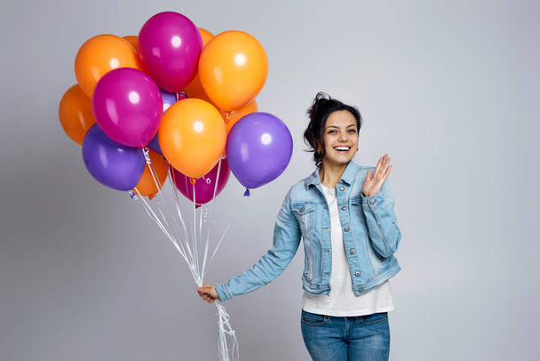 girl in denim posing with bright colorful air balloons - 写真・画像