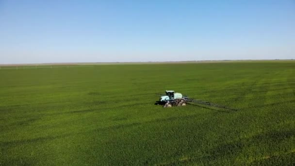 Landbouwmachines die insecticide spuiten op het groene veld, agrarische natuurlijke seizoensgebonden lentewerken. - Video