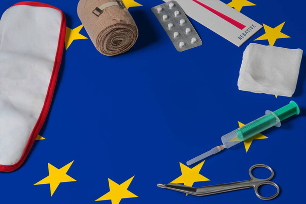 European Union flag with first aid medical kit on wooden table background. National healthcare system concept, medical theme. - Foto, Imagem