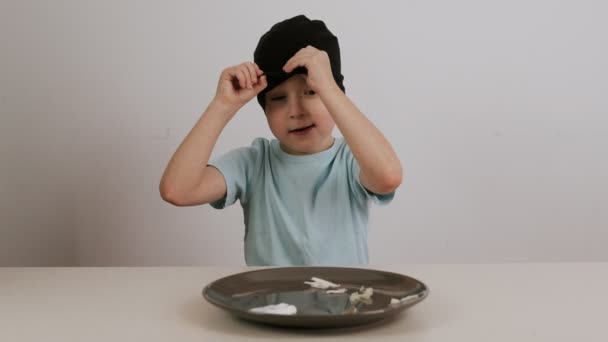 Un garçon dans un masque noir essaie et devine une variété d'aliments et donne pouces vers le haut
 - Séquence, vidéo