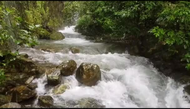 Piękny wodospad płynący z kamienia i tropikalnego tła lasu w deszczowy dzień w Doi Sam Muen, Tak, Tajlandia. Punktem orientacyjnym dla osób podróżujących i spacerujących  - Materiał filmowy, wideo