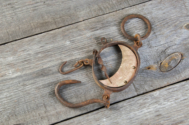 Balanças de mão enferrujadas de ferro de latão antigo com ganchos em fundo de madeira. Espaço de cópia para texto
. - Foto, Imagem