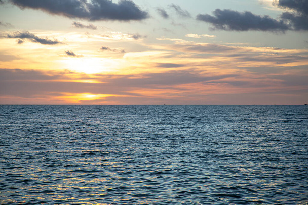Фон, прекрасний різнокольоровий захід сонця на океані. Подорожі та релаксація
. - Фото, зображення