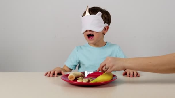 Little boy in a mask tries and guesses banan - Footage, Video