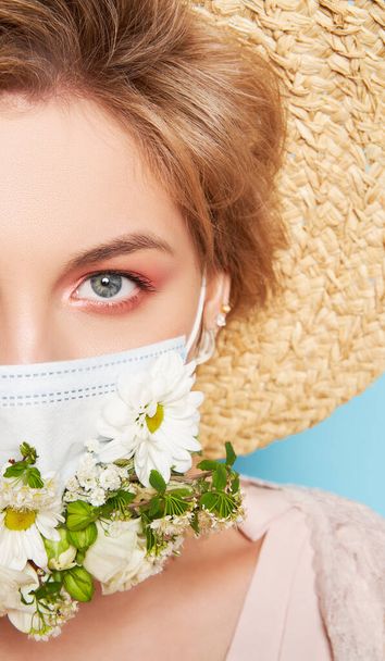 Face mask design with flowers. Portrait of beautiful woman with blue eyes, straw hat and mask - Foto, Bild
