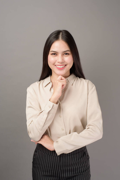 Portrait of beautiful business woman smiling on gray background  - Фото, зображення