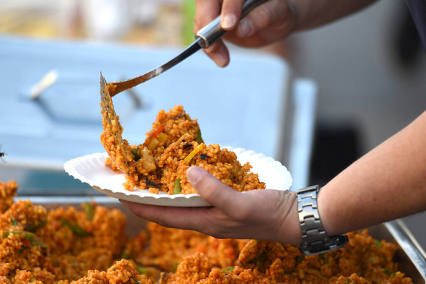 Servírování paelly na talíři - Paella je smažená španělská rýžová mísa  - Fotografie, Obrázek