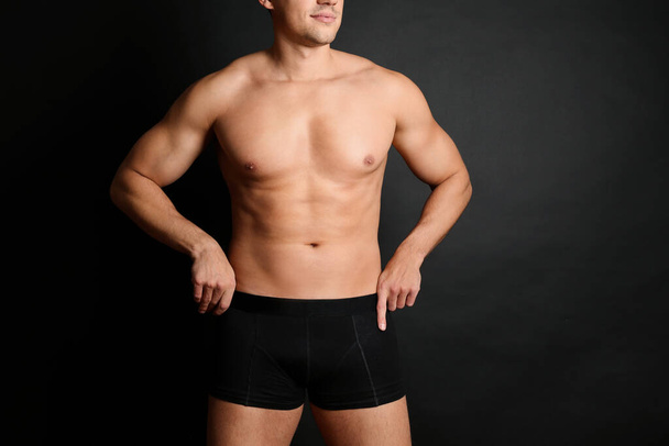 Man with sexy body on black background, closeup. Space for text - Foto, immagini
