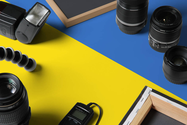 Ukraine national flag with top view of personal photographer equipment and tools on white wooden table, copy space. - Photo, image