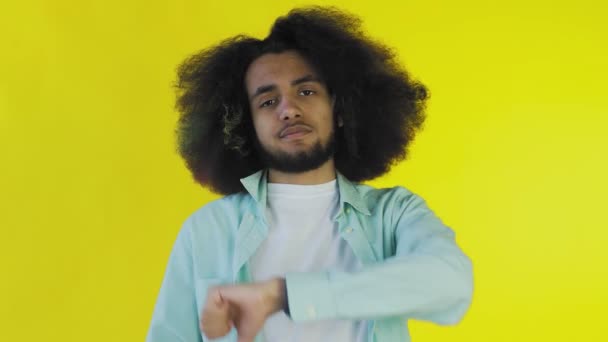 Afroamerikanischer Mann gestikuliert mit Daumen nach unten auf gelbem Hintergrund - Filmmaterial, Video