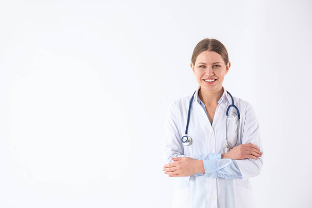 Portrait of young doctor against white background - Foto, Bild