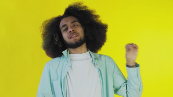 A fiatal afro-amerikai férfi csendet vagy bla bla gesztust mutat a sárga háttérben. Az érzelmek fogalma - Felvétel, videó