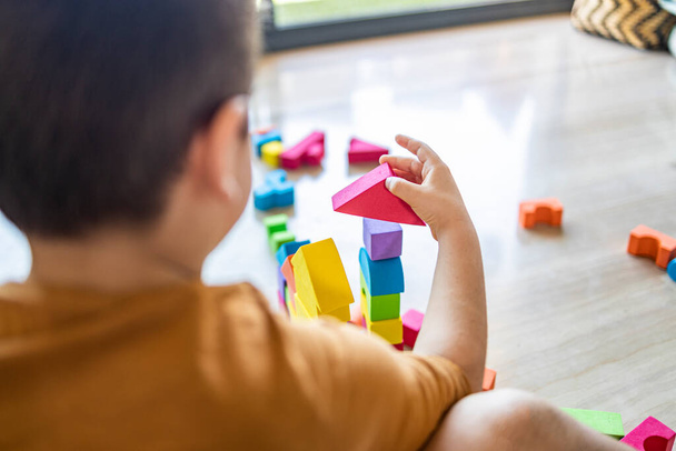 Забавный мальчик играет с блоками дома
 - Фото, изображение