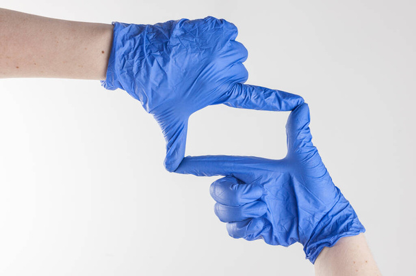 Imagem de perto recortada de uma mão humana usando luvas cirúrgicas azuis
. - Foto, Imagem