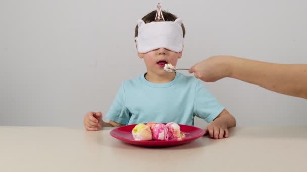 Mały chłopiec w masce próbuje zgadnąć lody - Materiał filmowy, wideo