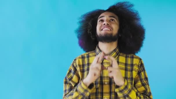 Portré az imádkozó afro-amerikai fickóról, aki drukkol és sikoltozik a kék háttéren. Az érzelmek fogalma - Felvétel, videó