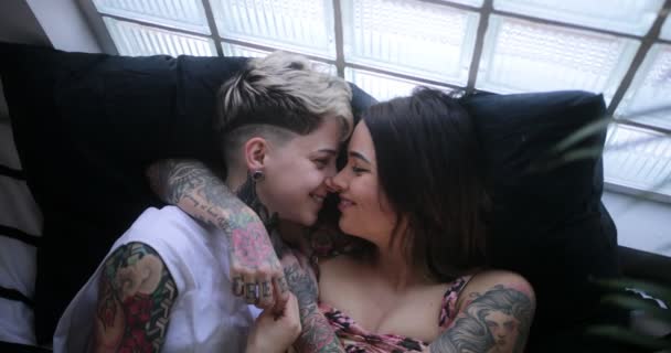 Lésbicas casal deitado na cama abraçando e acariciando uns aos outros
 - Filmagem, Vídeo
