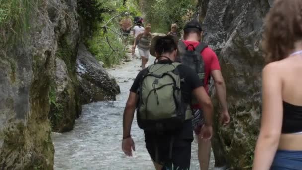 Excursão de caminhantes caminhando ao longo de um leito de rio - Filmagem, Vídeo