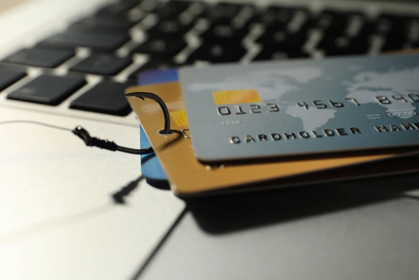 Horgászkampó hitelkártyával a laptopon, közelkép. Számítástechnikai bűnözés - Fotó, kép