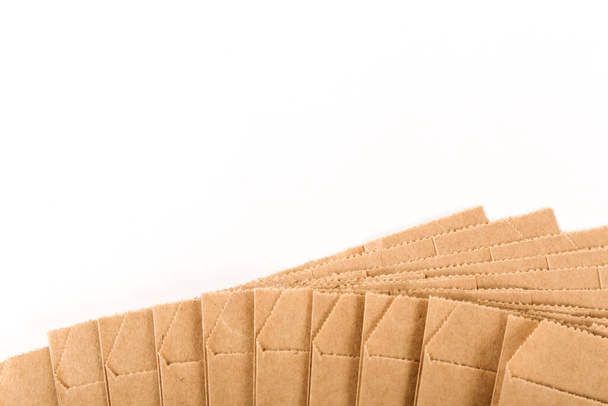 Neue braune Bastelpapiertüten fächerförmig auf weißem Hintergrund. Verpackungen für Waren, Lebensmittel, Briefe. Nahaufnahme. - Foto, Bild