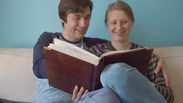 Couple in love watching family photo album - Záběry, video