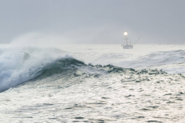 Риболовецький статут на узбережжі Орегону з бурхливим морем, коли день доходить до і закінчується товстим туманом на задньому плані і хмарним сірим небом. - Фото, зображення