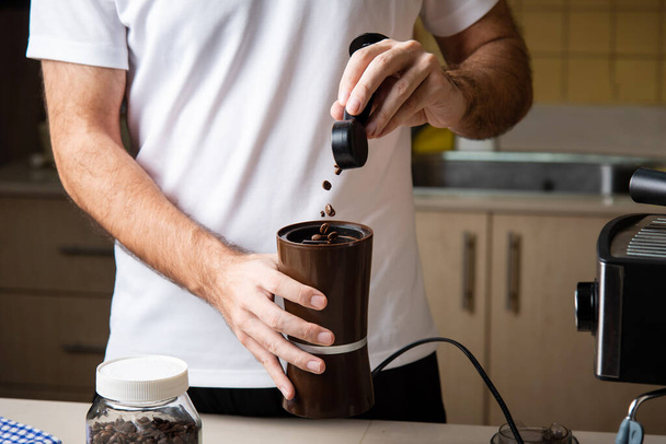Чоловік подрібнює кавові зерна для приготування еспресо. Домашня бариста концепція способу життя в приміщенні
 - Фото, зображення
