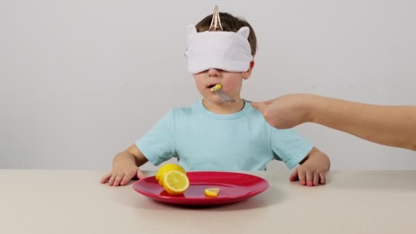 Little boy in a mask tries and guesses lemon - Footage, Video