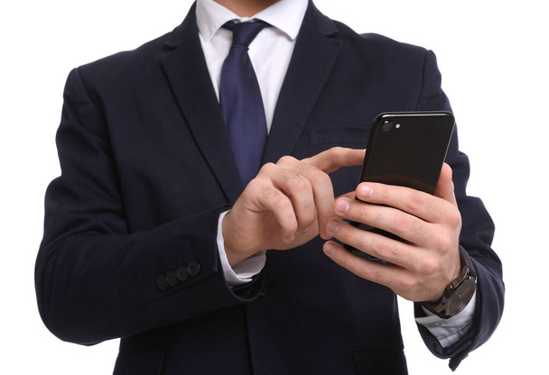 Young businessman with smartphone on white background, closeup - Photo, image