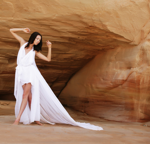 Woman in white dress dancing on the desert - Foto, imagen