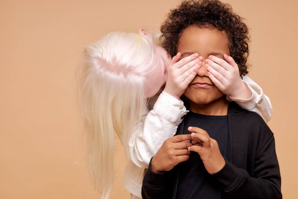 jongen en albino meisje spelen verstoppertje - Foto, afbeelding