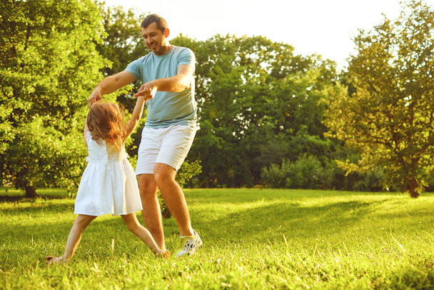 Fathers day. Father plays with his daughter in the summer park. - 写真・画像