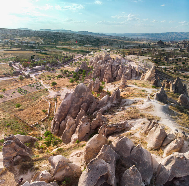 Aerial view of Goreme National Park, Tarihi Milli Parki, Turkey. The typical rock formations of Cappadocia with fairy chimneys and desert landscape. Travel destinations, holidays and adventure - Zdjęcie, obraz