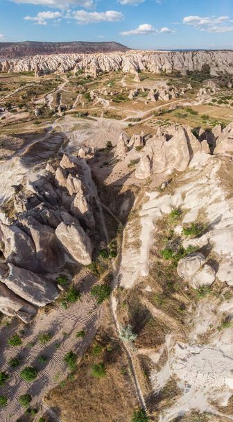 Aerial view of Goreme National Park, Tarihi Milli Parki, Turkey. The typical rock formations of Cappadocia with fairy chimneys and desert landscape. Travel destinations, holidays and adventure - Photo, Image