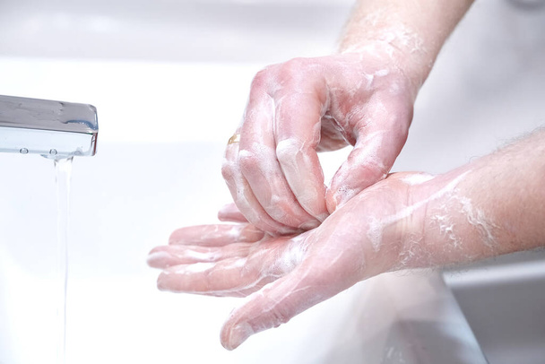 Homme se laver les mains avec du savon à la maison
. - Photo, image