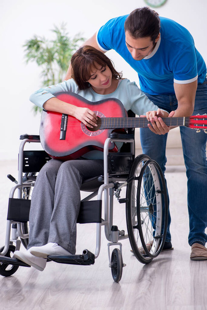 Disabled wife and young husband at home - Foto, imagen