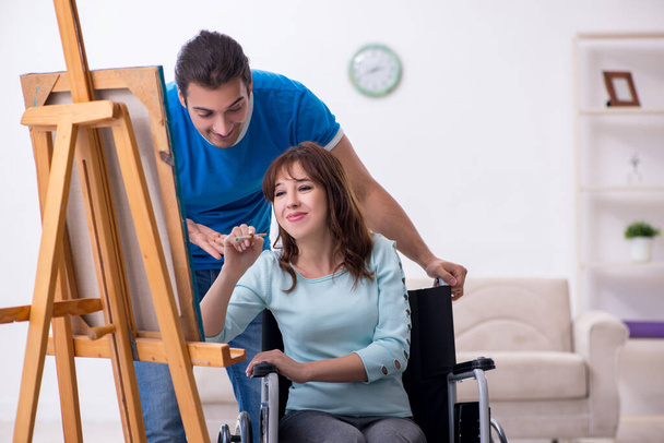 Disabled wife and young husband at home - Foto, imagen