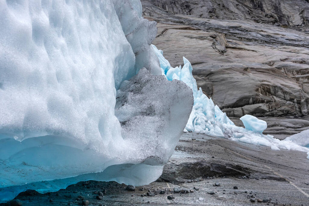 Jostedalbreen国立公園でナイガードブレーン氷河の氷と雪のクローズアップビュー。深い色の青い氷、岩、雪とノルウェーの山の風景ビュー。気候変動、氷河の融解 - 写真・画像