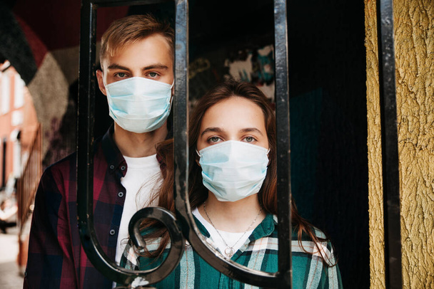 Couple in protective medical mask on face on street. Covid-19 virus quarantine concept. - Fotoğraf, Görsel