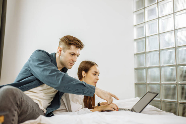 young couple watch film on laptop at home - Фото, изображение