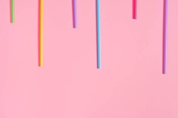 Rows of colorful straws for beverage on pink table. Space for text. Top view - Foto, imagen