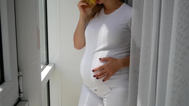 Pregnant Woman Drinking Orange Juice Near Window At Home. - Video