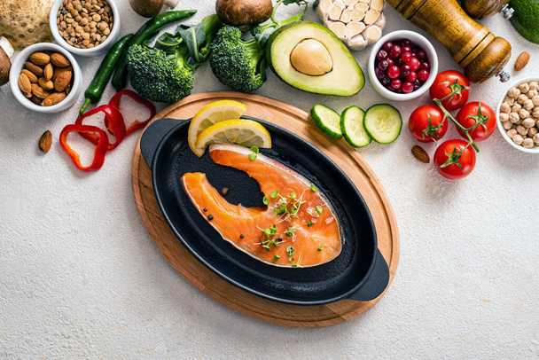 Raw salmon steak in a pan with healthy products. Healthy eating concept, food background. Top view. - Foto, Imagen