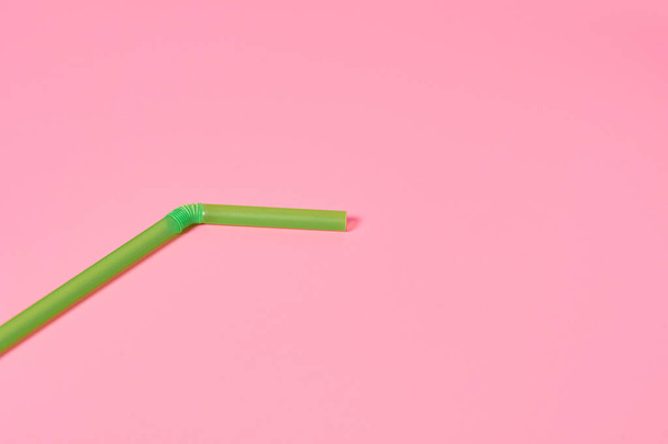 One green straw for beverage on pink table. Space for text - Fotó, kép
